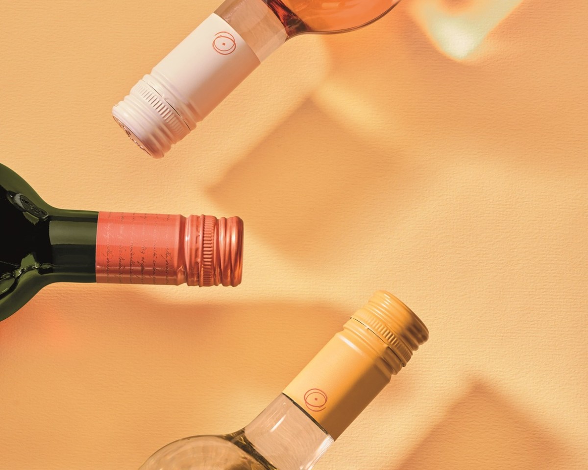 Three wine bottles with white, copper-colored and gold-colored Crealis screw caps.