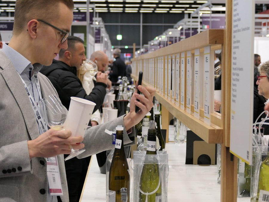 An attendee reviewing wines at a tasting counter during the World Bulk Wine Exhibition.